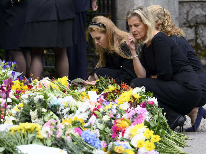 Rooke photographed the "grief-stricken faces" of Princess Beatrice and Sophie, Countess of Wessex, as they looked through flowers left in the Queen