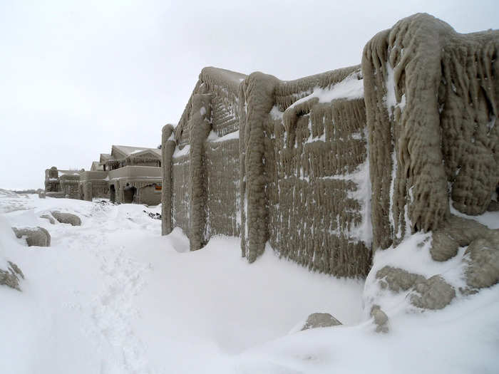 The ice-covered homes look like something from a sci-fi film as they sit covered in thick frost and ice along the water.