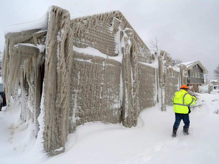 A man was seen inspecting his icy house after it got slammed by waves from Lake Erie and froze over.