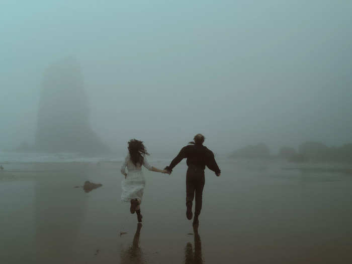 This married couple almost blends in with the misty beach.