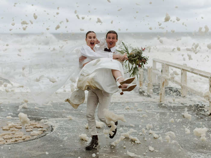 The ocean played a vital part in this photo of a groom carrying his bride to dry land.