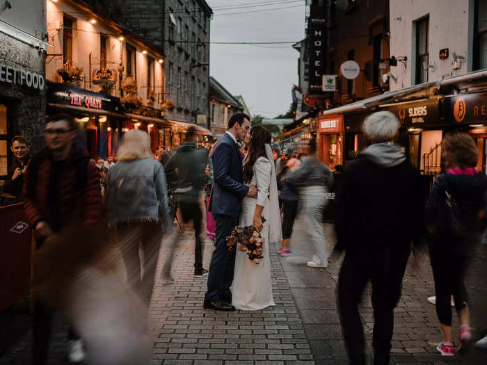 This bride and groom only have eyes for each other on a crowded street.