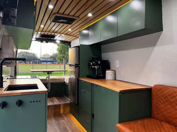 Toward the back of the bus is a kitchen area with custom-made cabinets and more secret storage.