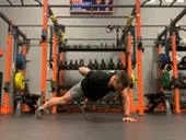 Jake Harcoff demonstrates a one-armed push-up, one of the best push-ups for improving strength