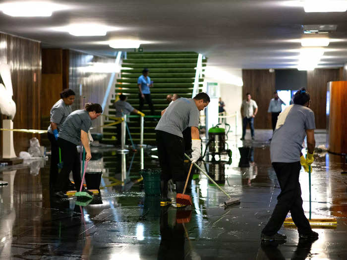 Clean-up crews got to work to erase the mess left behind after the riots in the Brazilian capital buildings.