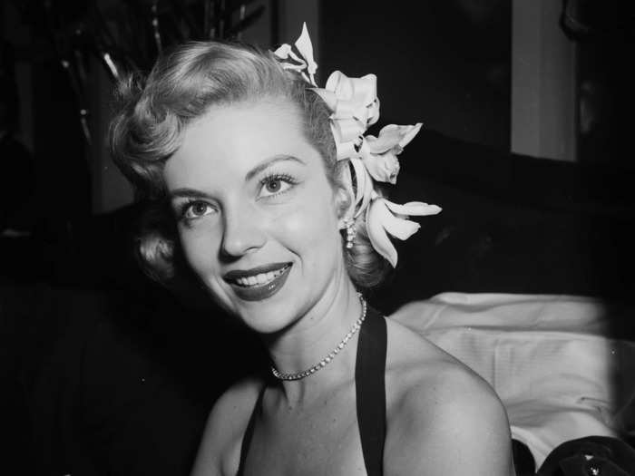 February 1952: Kathleen Hughes looked radiant in a lace, halter-style ensemble.