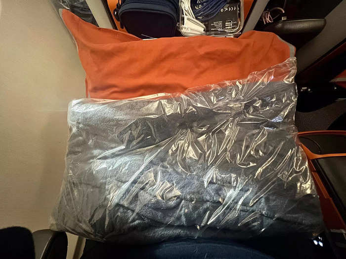 Waiting for me at my seat was a large pillow and plush blanket…