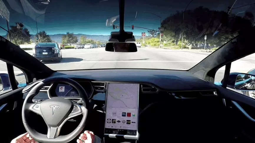 tesla in self-driving ad accelerating at a green light