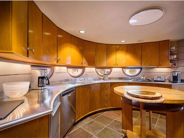 The kitchen includes curved countertops, inlaid lighting for the cabinets, and half-moon windows.