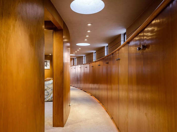 The hallways in Circle Sun House also include curved wooden storage cabinets