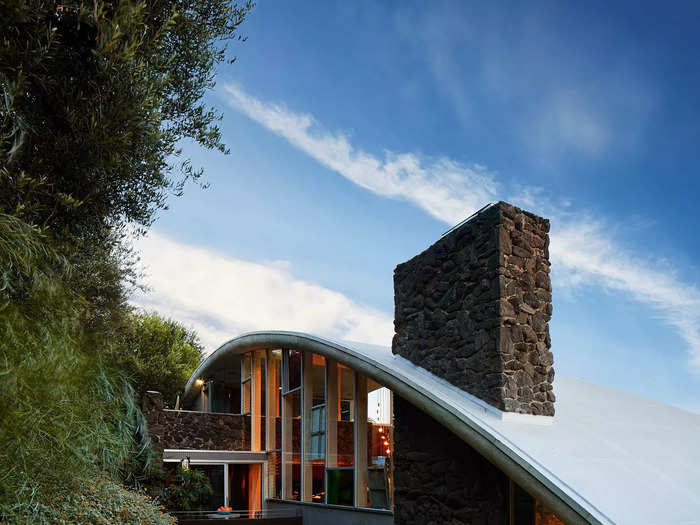 The house, which is listed with agent Aaron Kirman at AKG, appears almost like a half-moon rising above the landscape.