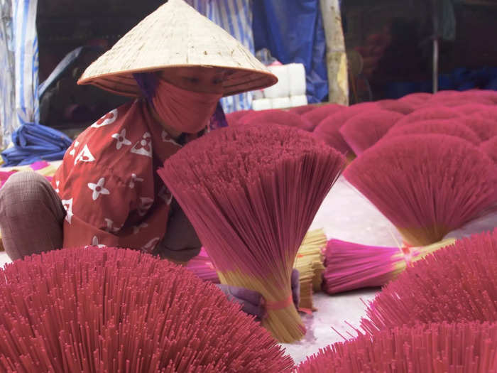 The bunches are meticulously fanned out around the town to dry, saturating Quảng Phú Cầu with its famed fuchsia hue.