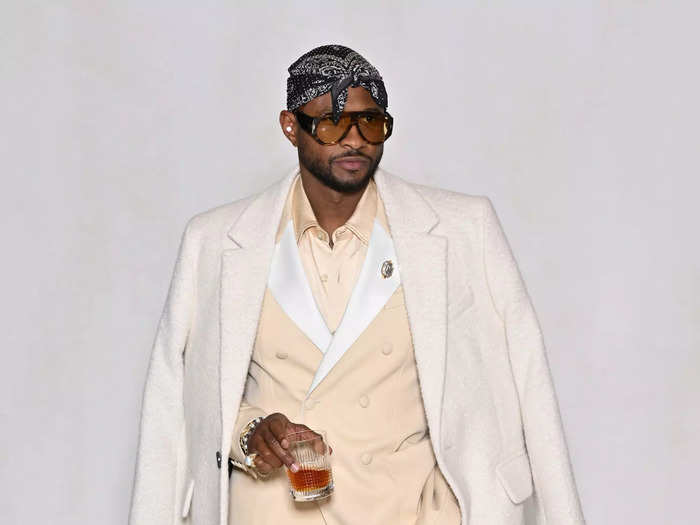 Usher rocked a stylish neutral suit with a coat draped over his shoulders at the Alexandre Mattiussi menswear show.