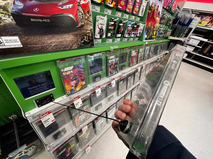 A video game display at Target used a tether to let shoppers look at a title, but required staff assistance to get a copy from a locker in order to buy it.