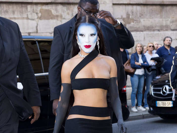 Doja Cat attended the Monot womenswear fashion show with bold blue and white face paint during Paris Fashion Week in October 2022.