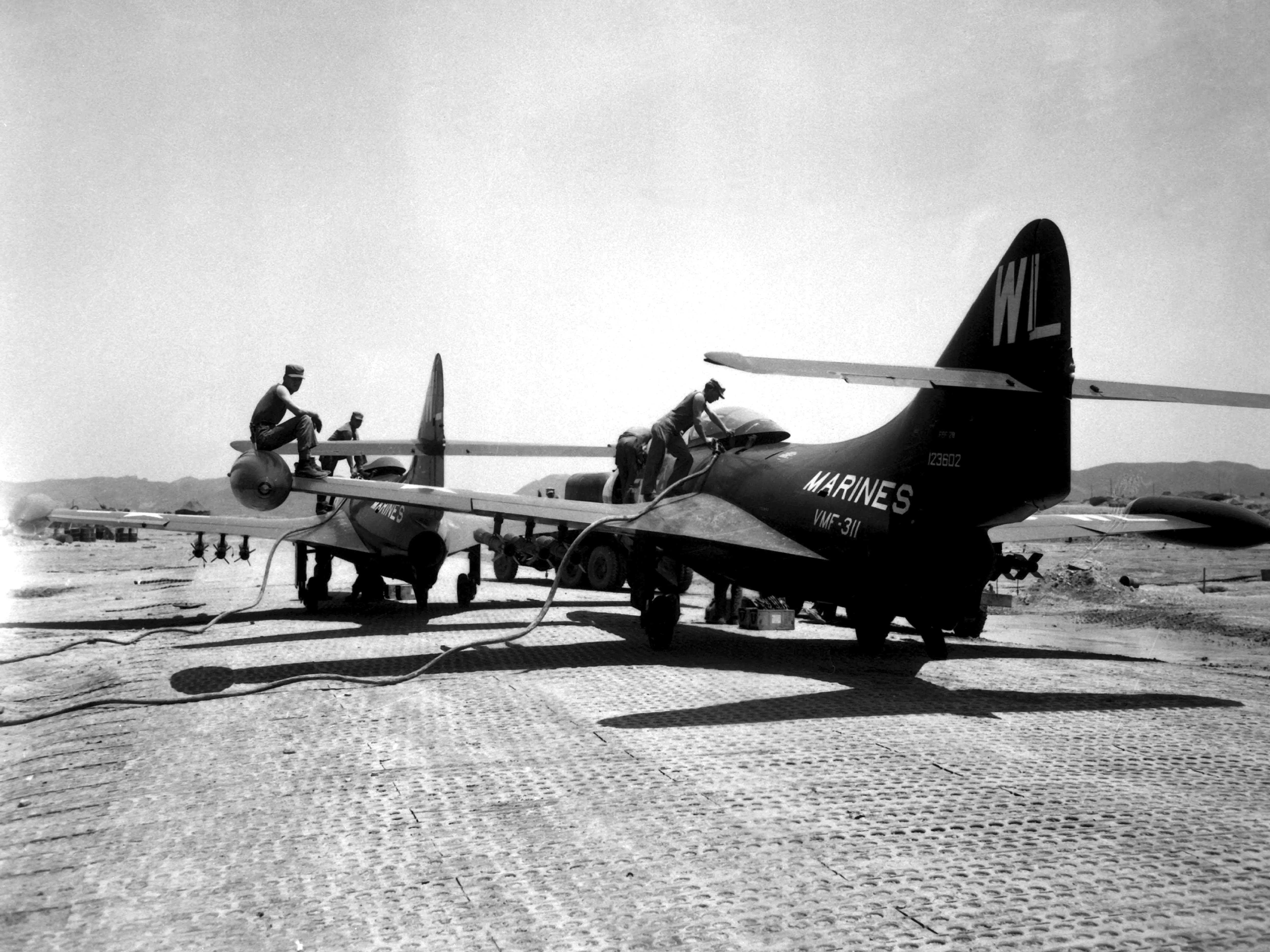 During the Korean War, two United States Grumman F9F Panther jet fighters are refueling after having been armed with rockets under their wings in 1951.