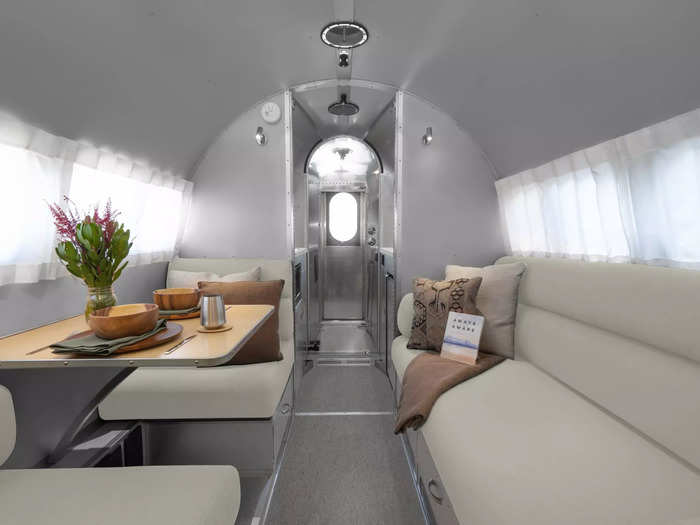 The silver and beige-grey interior has a dining and living room that can convert into two twin beds, allowing the trailer to sleep up to four people.