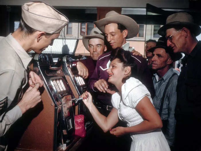 By 1940, there were about 8,000 residents in Las Vegas. Here, gamblers play the slot machines.