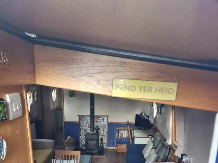 The entrance to the houseboat has several steps, with a sign overhead that reads: "Mind Yer Heid."