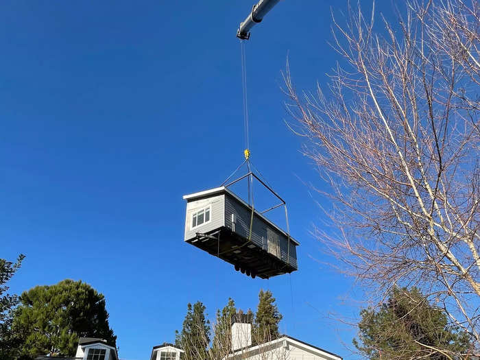 The house arrived on a truck in two pieces. A crane operator lifted the house off the truck and into the backyard.