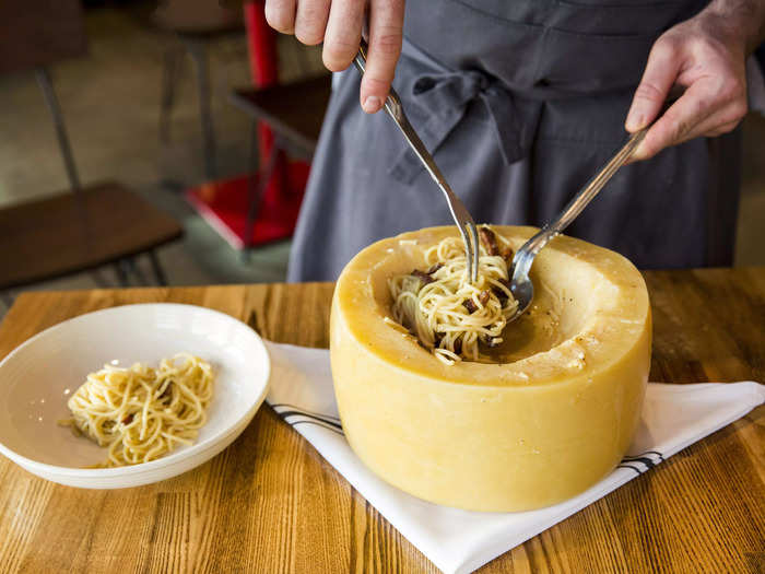 Dig into spaghetti tossed inside a cheese wheel.