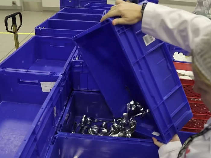 Before cooking, employees remove and clean trolleys, trays, plates, and other tableware from the incoming flight.