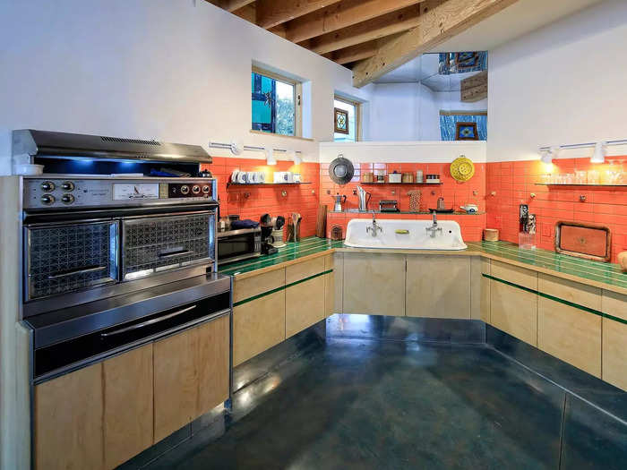 Bright orange tiles and polished concrete floors brighten up the kitchen.