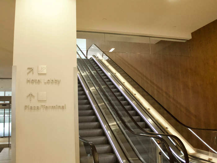 I walked through a set of glass doors and entered the hotel, where I saw elevators and escalators leading up to the lobby.