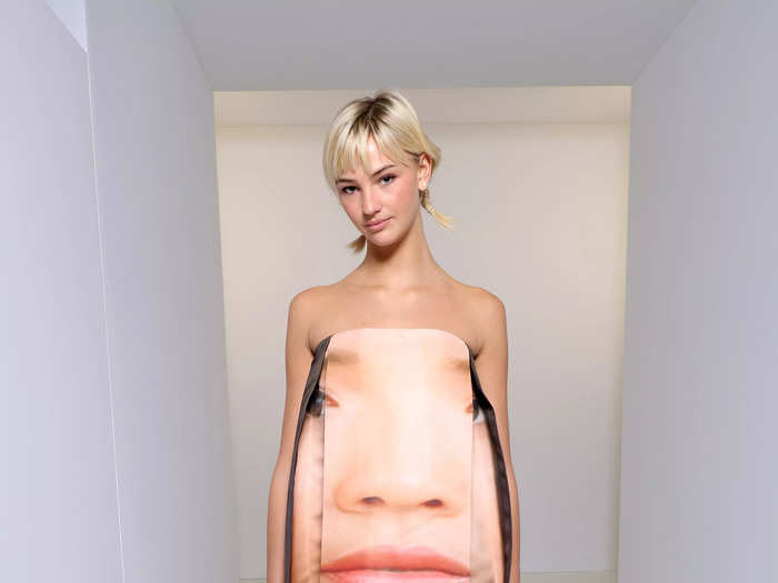 British model Mia Regan also turned up to the Loewe show in an eye-catching ensemble – a strapless mini dress with a face printed on it.