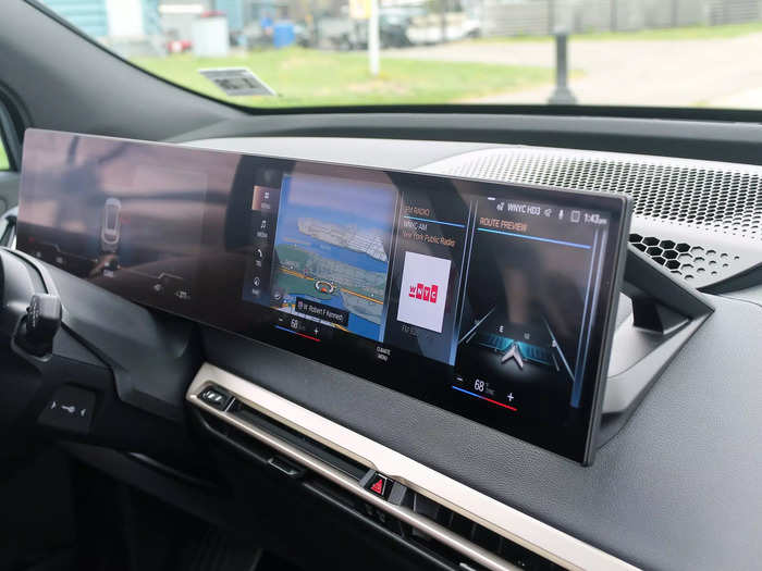 It has two modest screens elegantly suspended above the dashboard behind a strange, angular steering wheel.