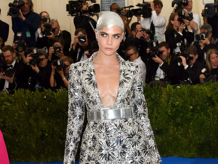 Delevingne painted her head a metallic silver to match her bold, low-cut silver starburst suit at the 2017 Met Gala.