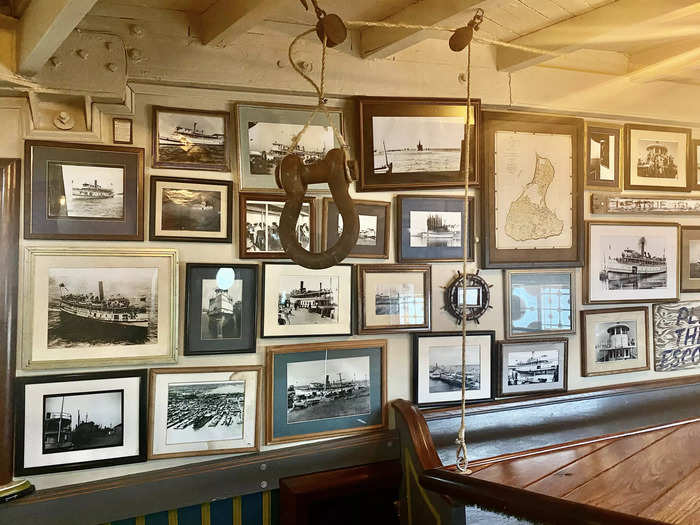 The walls of the cargo deck are covered in black-and-white photos detailing the ship