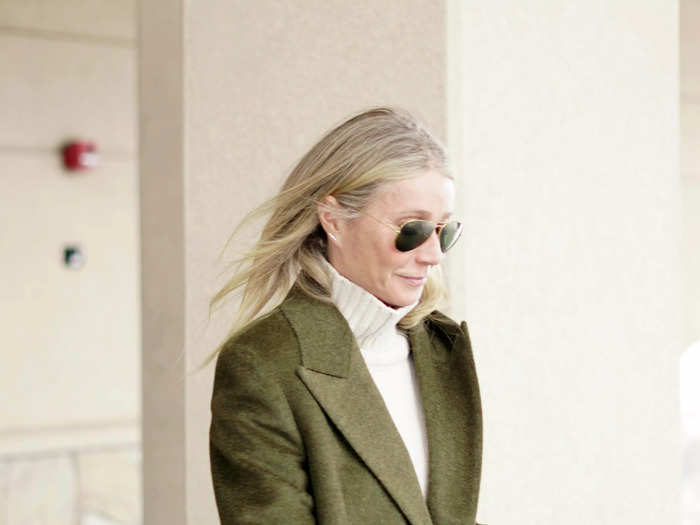 She paired the sweater with an ankle-length, olive green coat and brown trousers.