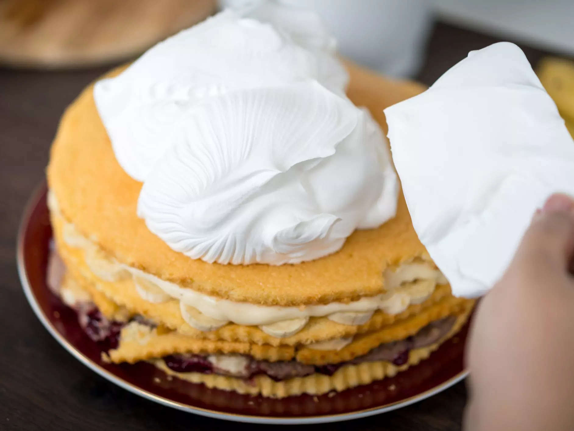 frosting a cake with whipped cream