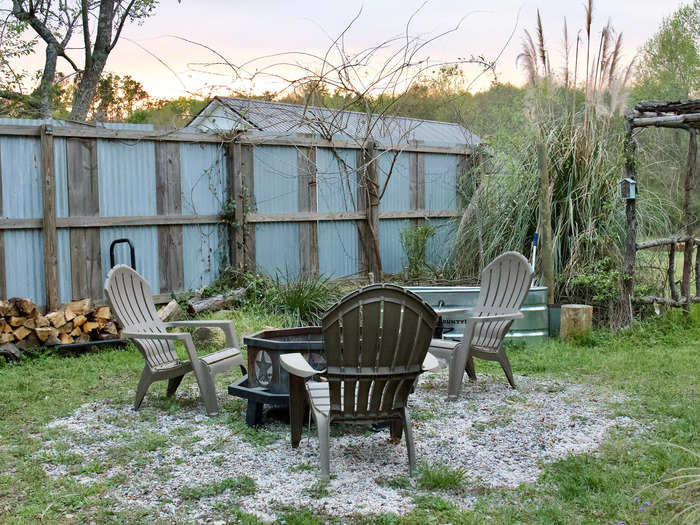 The backyard had a metal fire pit and three Adirondack chairs.