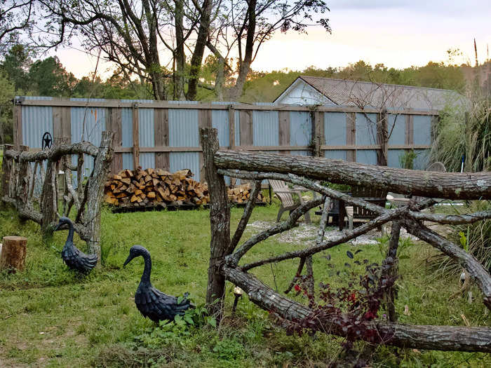 The grain bin had its own backyard, which was loosely enclosed by a metal privacy wall and a fence made of tree limbs.