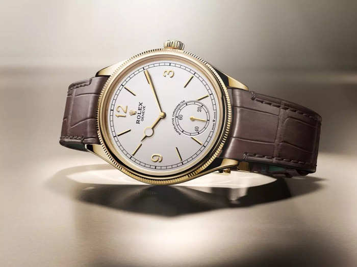 The elegantly simple design features a leather band and Arabic numerals at three, nine, and 12, with a seconds sundial at 6 o