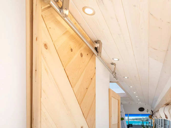 Past the kitchen is a hallway that leads to a bathroom. A barn door that Touserkani made from wood scraps opens to the bathroom.