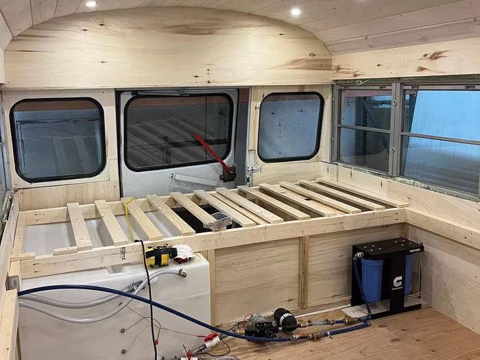 After the plumbing was put in, they built out the home from back to front. The first step was building a platform at the back of the bus for their bed.