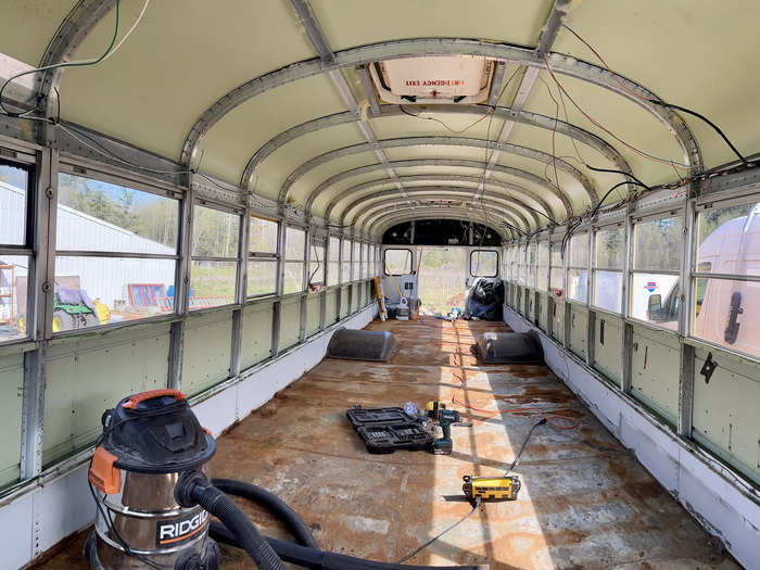 This is the bus at its most bare — after the couple removed the seats, luggage racks, insulation, wood panels, and rubber flooring.