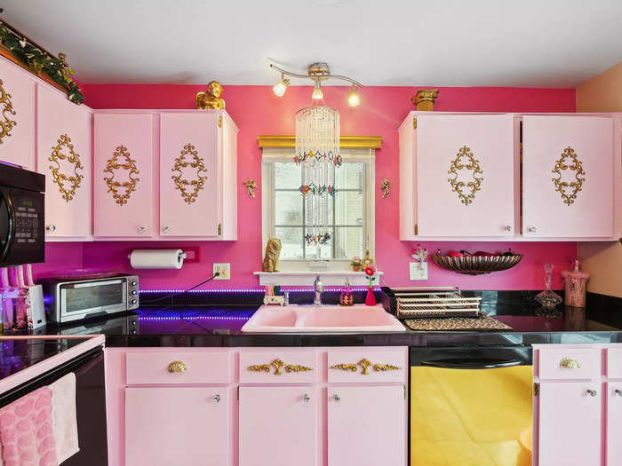 The kitchen was the first project that Penta worked on when she moved in. The cabinets were originally white, but she painted them pink and added gold appliques.