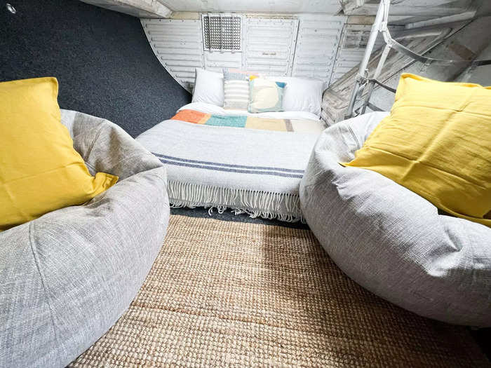 The cargo hold area has a double bed, bean bags, and a media system