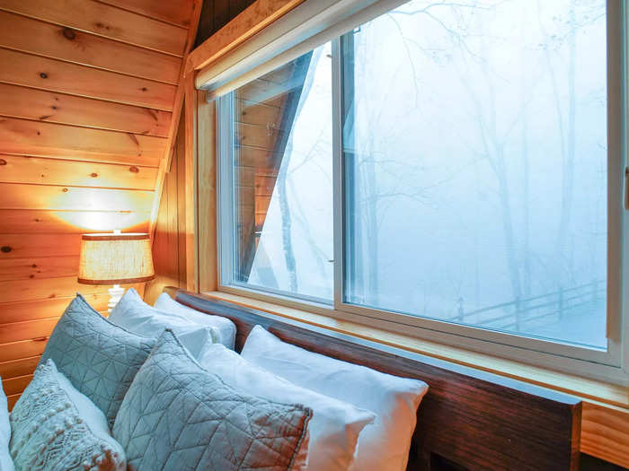 With wood paneling and vast windows, I thought the cabin made me feel immersed in nature from the comfort of a cozy bed in a heated home.