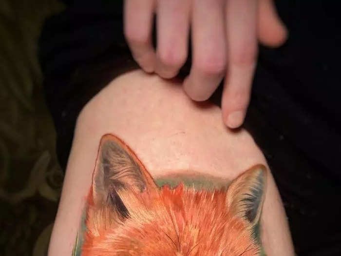 A whimsical fox and mushroom tattoo on the thigh