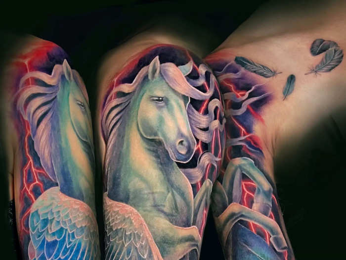 A full Pegasus sleeve covers arm scarring