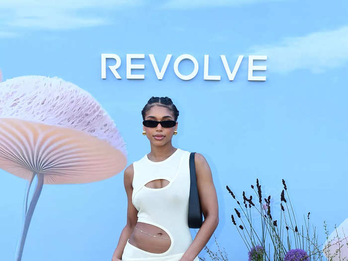 Lori Harvey wore a white dress with asymmetrical detailing for Revolve Fest.