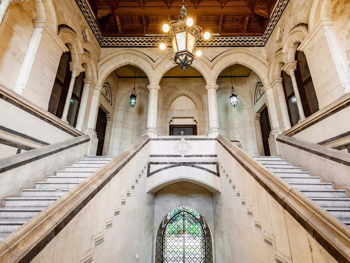 Inside, the main entrance opens to a grand hall with a marble staircase leading to the first floor.