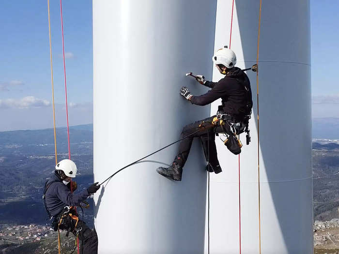 João and his partner repel down the blade and check it for damage by tapping it with a hammer. They can tell if the materials are fracturing underneath the fiberglass by the sound it makes.