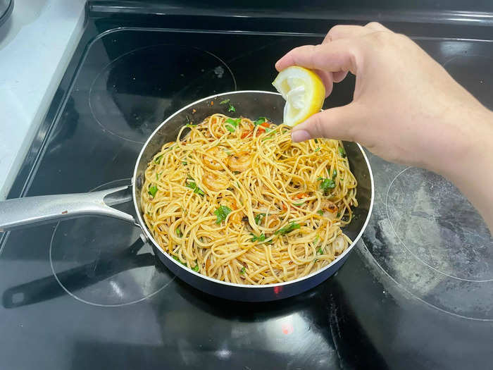 Serve the shrimp and garlic pasta hot, garnished with grated Parmesan cheese and lemon wedges for squeezing over the top