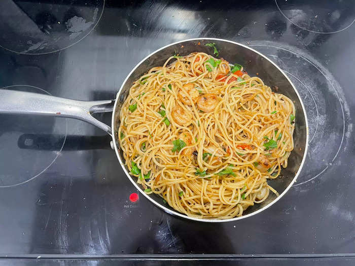 Return the cooked shrimp to the skillet along with the cooked pasta. Toss everything together to coat the pasta with the sauce. Cook for 1-2 minutes to heat everything through.